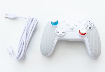 Modern white video game controller with a charging cable © YouraPechkin