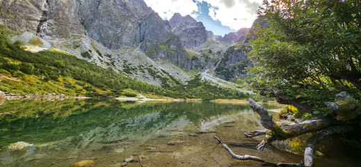Zielony Staw Kiezmarski mountain lake surrounded by rocky slopes of Slovak Tatras with reflections © Liubou