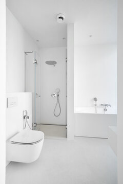 Modern empty clean white bathroom interior mockup with bathtub, glass shower cabin, and toilet.