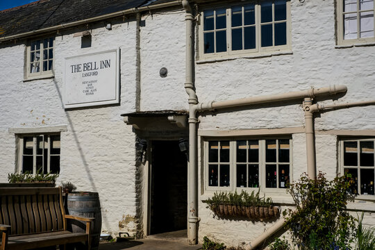 Langford, UK - April 7, 2026. Traditional Historic Country Pub The Bell Inn in Langford Village Cotswolds. A high-detail horizontal photograph capturing the exterior facade of The Bell Inn, a classic 