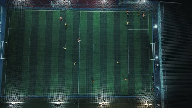 Top down night view of a football pitch under floodlights