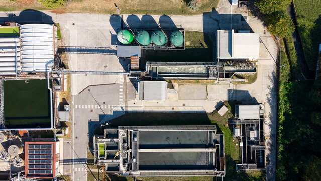 Aerial view of the wastewater treatment plant with sedimentation tanks, filtration units, and industrial infrastructure in Rancate, Lombardia, Italy.