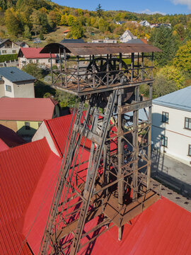 Aerial view of the historic Jama Ferdinand headframe, a weathered metal mining structure standing above red-roofed buildings in Ziar nad Hronom, Banskobystricky kraj, Slovakia.