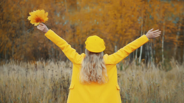 Happy woman in autumn park, joyful girl enjoying warm sunny weather, nature
