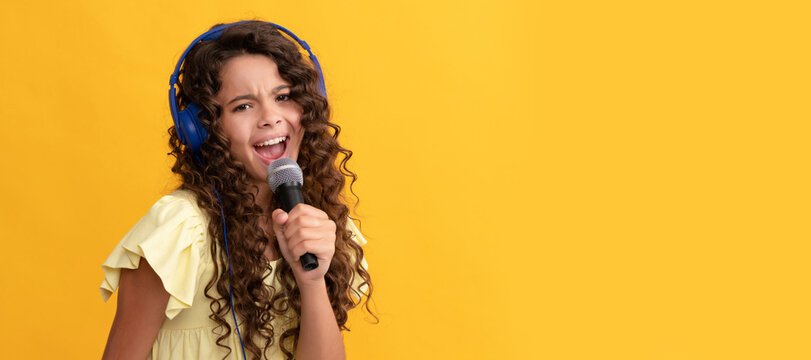 new technology. childhood development. child singer sing karaoke in microphone. Child portrait with headphones, horizontal poster. Girl listening to music, banner with copy space.