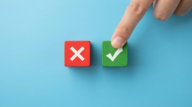 A finger pressing a green wooden block with a check mark next to a red block with a cross