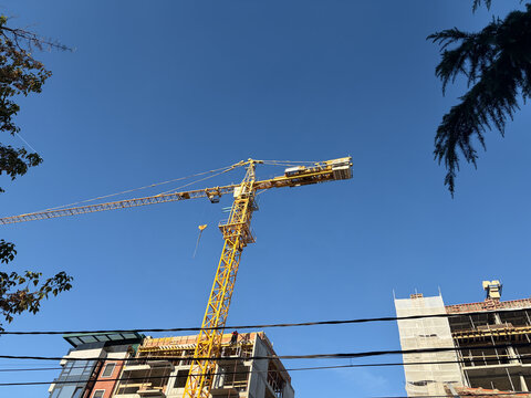 Yellow tower crane above new apartment buildings in an urban development zone