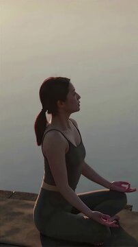 Silhouette profile of a person meditating in a zazen pose against a warm golden hour sunset light, 4K, Seamless loop, Copy space on the top, front view, Vertical image