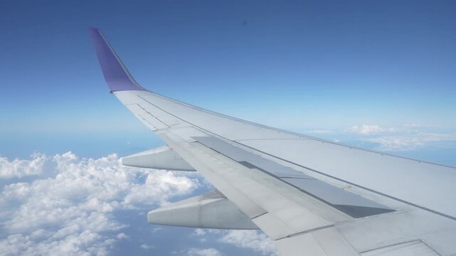 Commercial airplane flying in clear blue sky during high altitude flight.