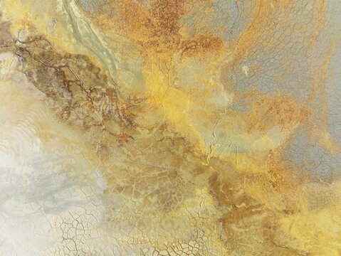 Abstract patterns in a waste pond in the mineral-rich area of the Rio Tinto mines. The colour is caused by oxidised iron minerals. Aerial view. Drone shot. Huelva province, Andalusia, Spain