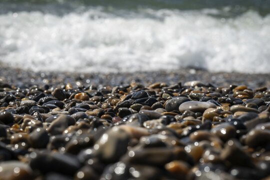 Wet pebbles with surf in the background, Houvig Beach, North Sea, Denmark