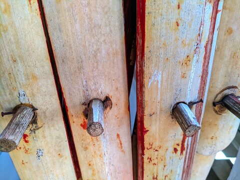 Close Up of Vintage Wooden Pegs and Rusty Nails in Planks