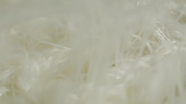 White fur texture with hand touching, close up of fluffy faux fur and natural sheepskin rug, soft long hair fur background in fur shop from Turkish fur factory production