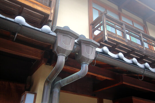 A Japanese-style copper rain gutter system installed along the eaves of a traditional-style house (such as one featuring authentic Japanese or Ko-Edo style architecture).