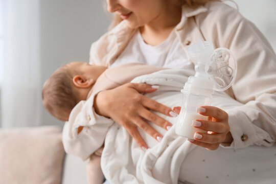 Breastfeeding support and motherhood, mother holding a baby and a breast pump for infant nutrition and lactation care in a home environment