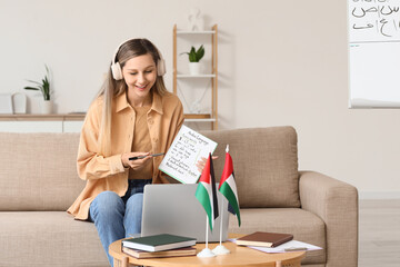 Arabic language learning, online tutor teaching foreign language via video call with laptop and notebook at home © Pixel-Shot