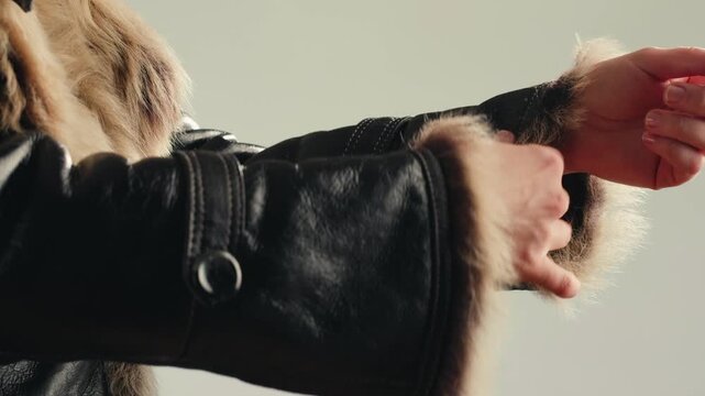 Sheepskin coat with fox fur collar, close up of woman in leather jacket with fluffy fur hood, warm shearling outerwear in fur shop from Turkish leather factory production