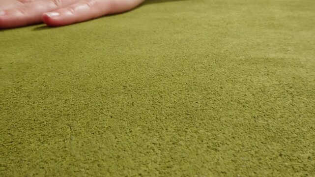 Nubuck texture with woman hand touching, close up of red, orange and green suede leather surface, soft natural nubuck material sample in leather shop and factory