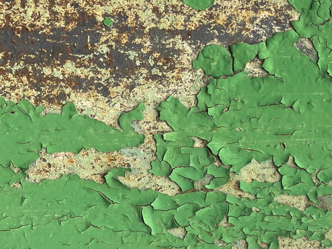 Close-up peeling green paint on rusty corroded metal surface showing cracked texture and flaking layers of aged coating and exposed substrate under weathered finish