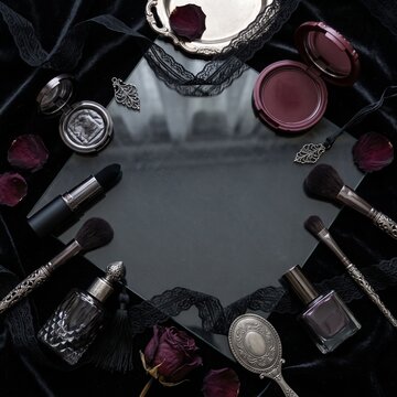 Cosmetic collection flat lay featuring vintage black lace mirror and dried rose petals decor.