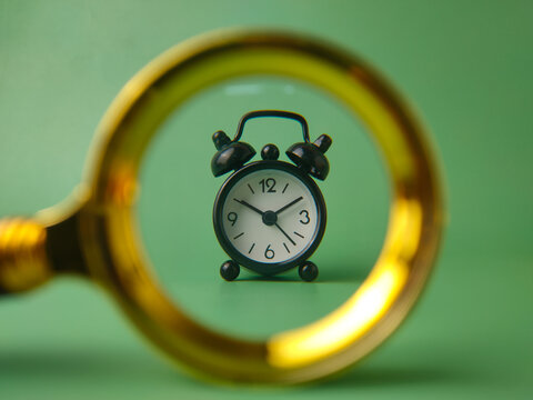 Black Alarm Clock Framed in Magnifying Glass Lens