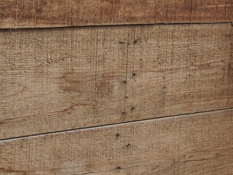 a rustic, weathered wooden plank surface showcasing natural timber grain, rough textures, and horizontal structural seams