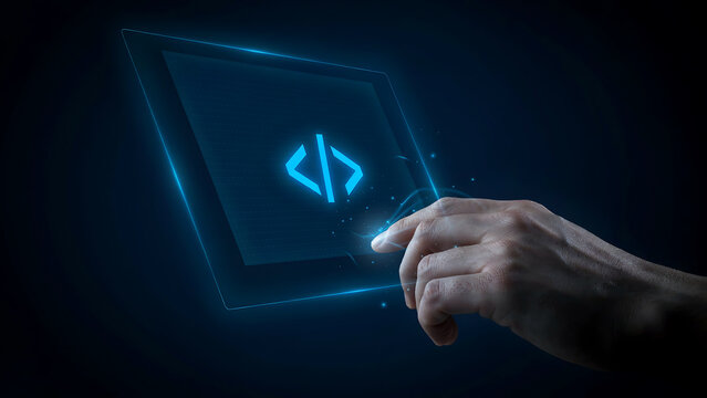 A human hand touches a glowing digital code icon on a futuristic touchscreen display in the dark. Perfect for software development and programming concepts.