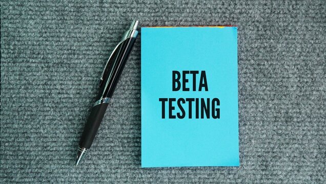 Pen and paper with the word Beta testing is the second phase of pre-release software testing where a group of real-world end-users tries out an application, website, or digital product