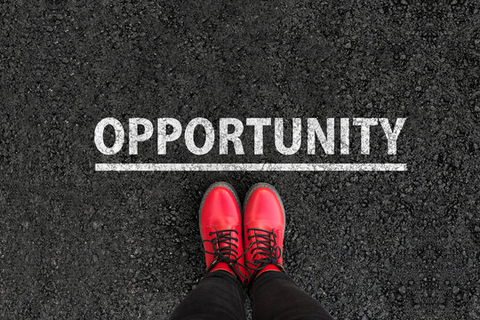Person standing on asphalt road next to Opportunity word text painted on pavement, concept of decision, future choice and career growth.
