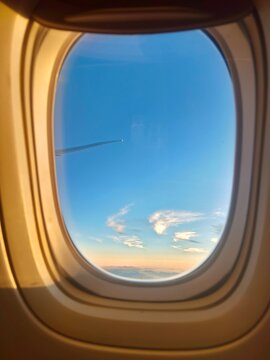 view of white clouds and blue sky from airplane window