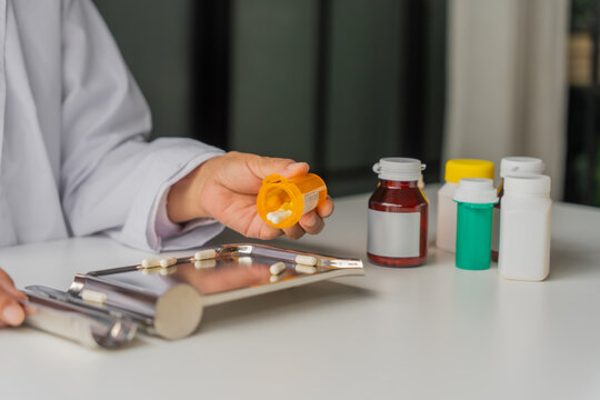  Mature Asian pharmacist using medication tray