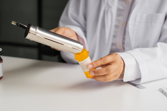  Mature Asian pharmacist using medication tray