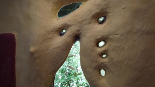 Close Up of Clay Adobe Cob House Window With Jungle Forest Background in Permaculture Eco Home