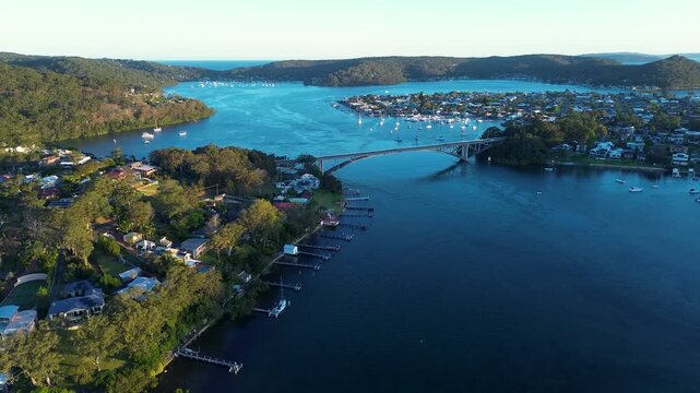 Drone aerial landscape of The Rip Bridge connecting Blackwall and Daleys Point suburbs beside Brisbane Water and residential town housing along the waterfront foreshore on the Central Coast Australia
