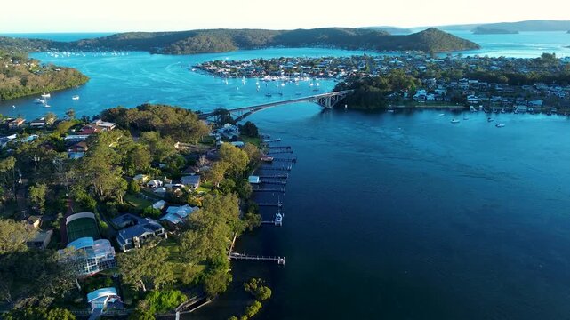 Drone aerial landscape of The Rip Bridge infrastructure with residential housing and jetties surrounded by Brisbane Water waterways and bushland headland at Daleys Point Central Coast of NSW Australia