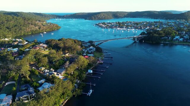 Drone aerial landscape of The Rip Bridge surrounded by suburban residential housing along the waterfront foreshore with bushland forest on the horizon at Daleys Point on the Central Coast Australia
