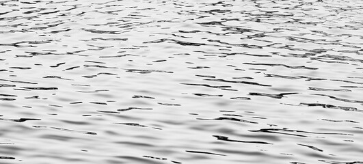Abstrakter Hintergrund mit Lichtreflexionen auf welligen Wasser,Monochrome, © sida