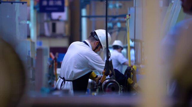 Focused factory engineer man checking status, operating advanced CNC machines, precision engineering, industrial productivity, skilled craftsman worker wearing safety helmet maintenance repairing