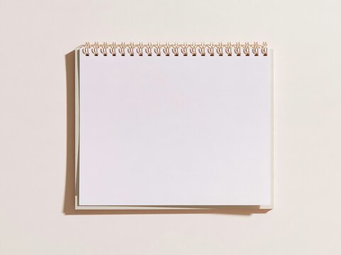 Blank spiral notepad with a metal coil and smooth paper on a soft lavender backdrop, a clean template for stationery and planner designs