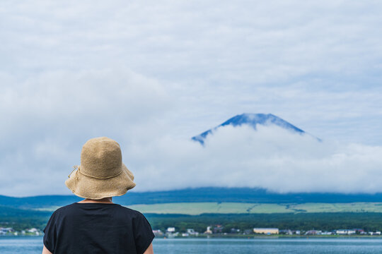 後ろ姿の女性と富士山｜山中湖・湖畔から夏の富士山を眺める女性・日本の風景