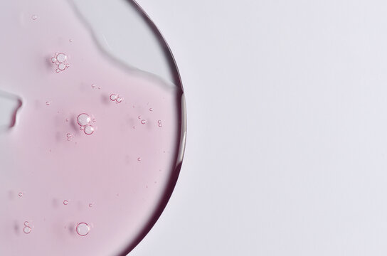 Pink cosmetic product for skin care. A serum or body gel or a moisturizer. Copy space