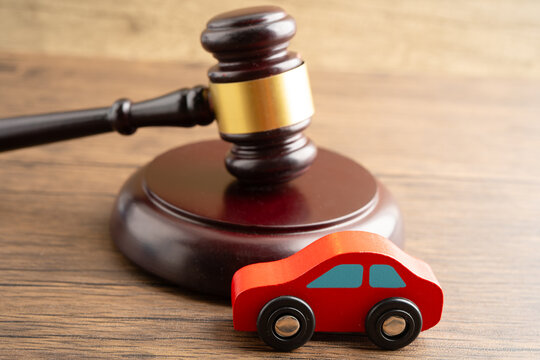 Car accident lawsuit and insurance, Judge hammer with car model.