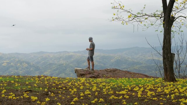 Drone Pilot Overlooking Yellow Flowering Mountains