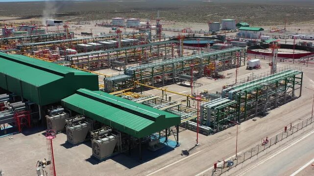 Drone shot showing an aerial view of the Fort&iacute;n de Piedra gas processing plant in the Vaca Muerta shale reserve, Neuqu&eacute;n, Argentina. Green roofs; yellow, white, and red pipes. 4K.