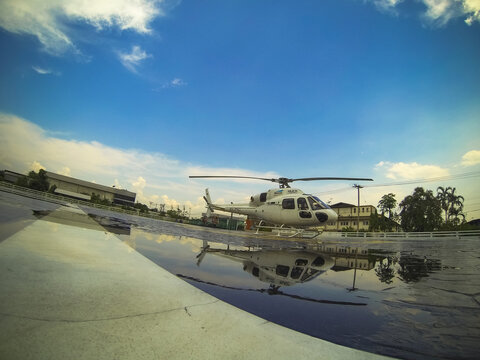 Stock footage of an AS355NP twin-engine helicopter parked outdoors in Thailand. Shot from a ground perspective.