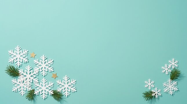 Festive snowflakes and evergreen branches arranged on teal background, perfect for holiday season concept and seasonal designs