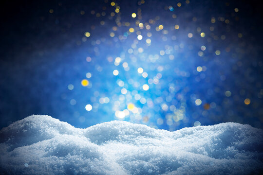 Magical abstract winter snow landscape with glowing blue and gold bokeh lights