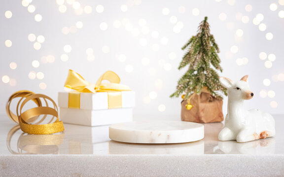 Empty round marble podium with elegant Christmas objects composition on reflective table surface