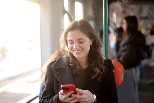 Happy woman using her phone on public transport