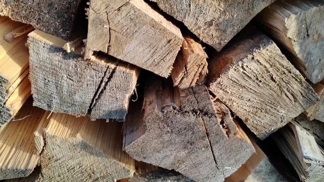 Closeup video of a rustic pile of chopped firewood in warm sunlight
